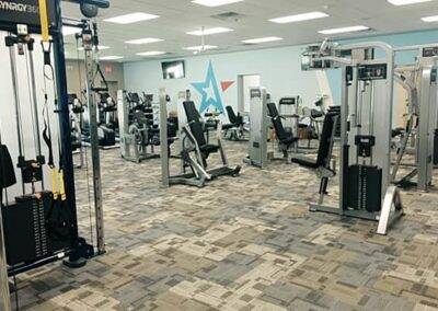 Modern gym interior with various exercise machines, including treadmills and weight stations, clean and well-organized.