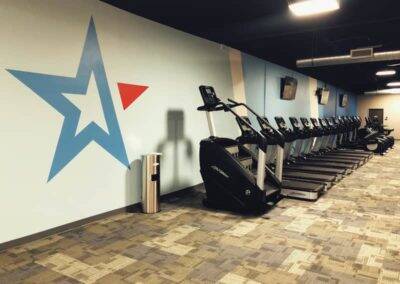 A row of treadmills in a gym with a large star graphic.